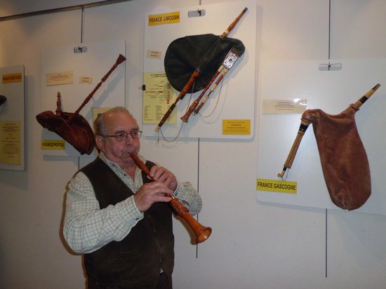 Alan Le buhé vous guide à travers la collection. Il est ici au hautbois du Poitou, devant la cabrette du Limousin, à la médiathèque d'Elven.